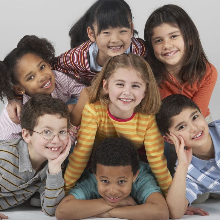 Group of smiling children from diverse backgrounds posing together, symbolizing multicultural and international community.