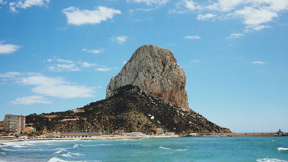 Peñón de Ifach standing tall in the middle of the frame, taken in Calp Spain. Surrounded by the ocean.