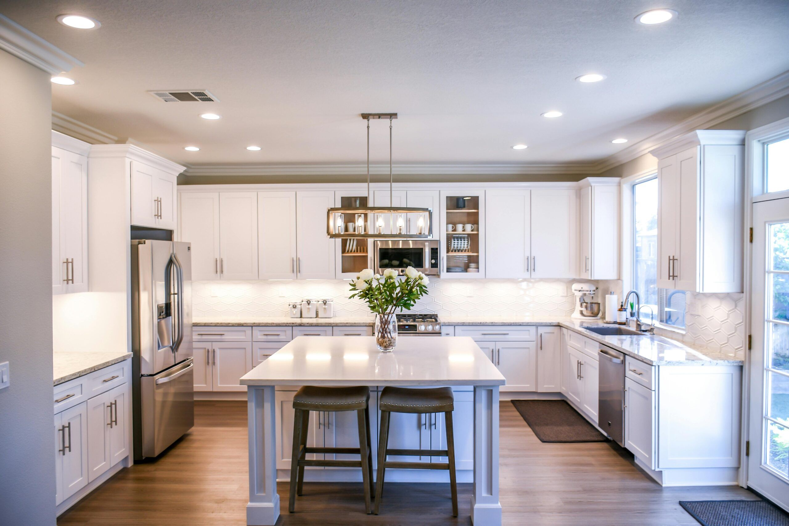 Renovated modern kitchen with central island and stainless steel appliances, a high-impact upgrade to boost rental value.