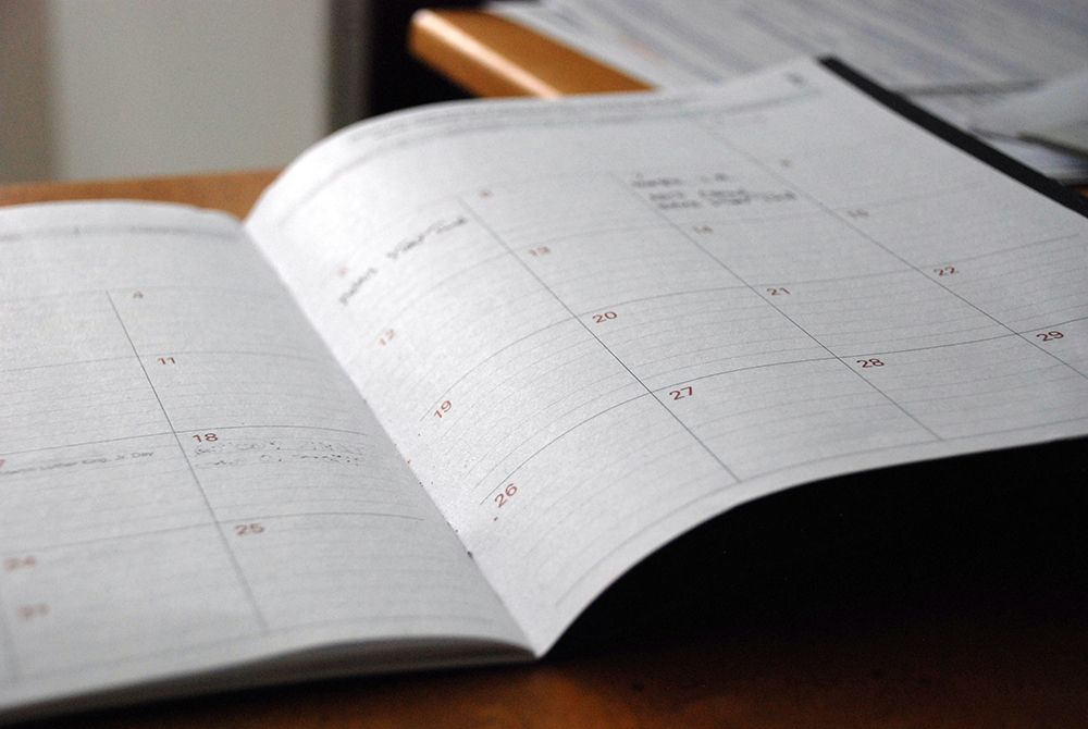 Close-up of an open planner or calendar showing blank daily squares for scheduling and note-taking.