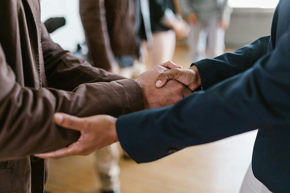Close-up of two people shaking hands, symbolizing agreement or closing a deal.