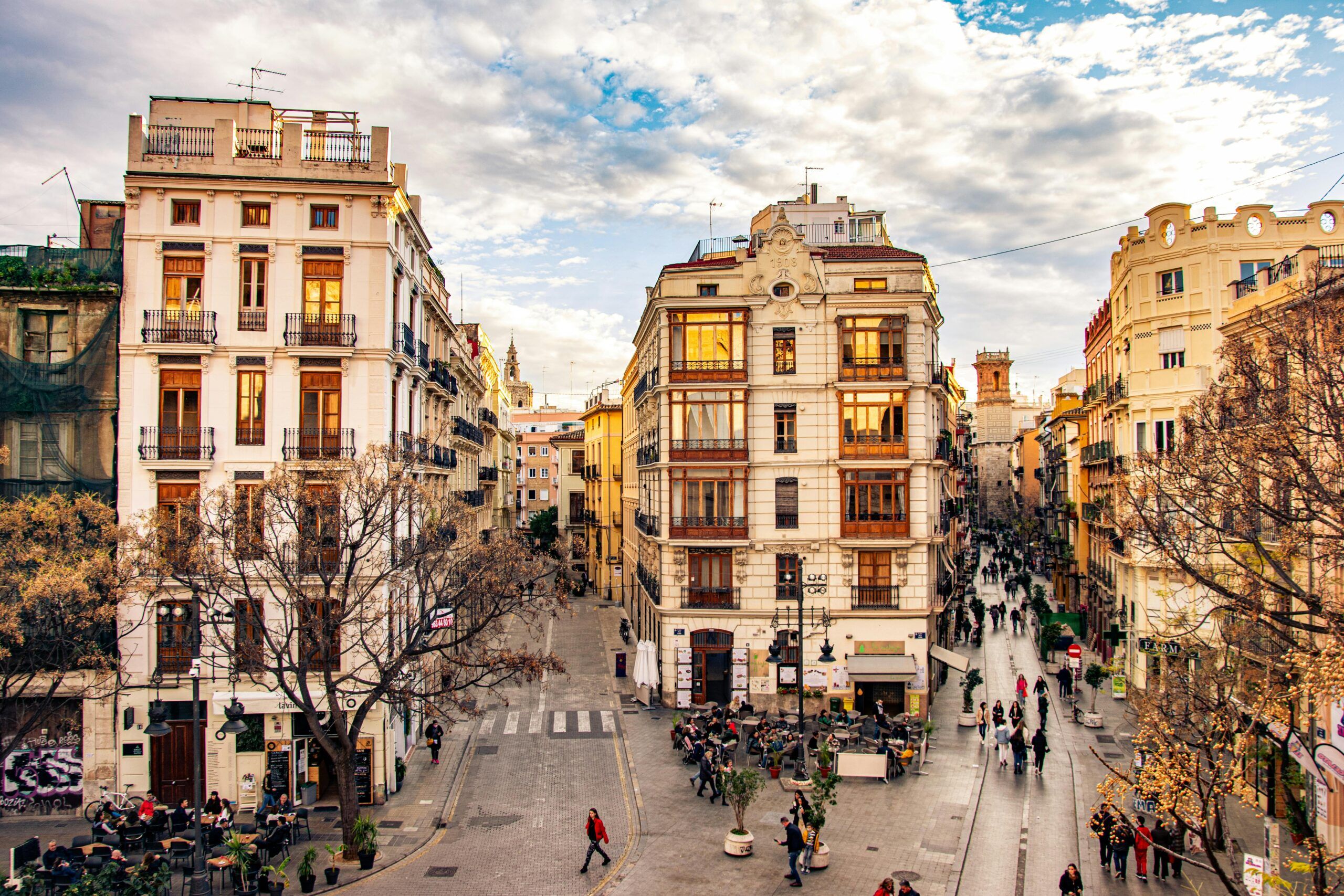 Busy street in Valencia Spain with historic buildings, shops, and people walking in November
