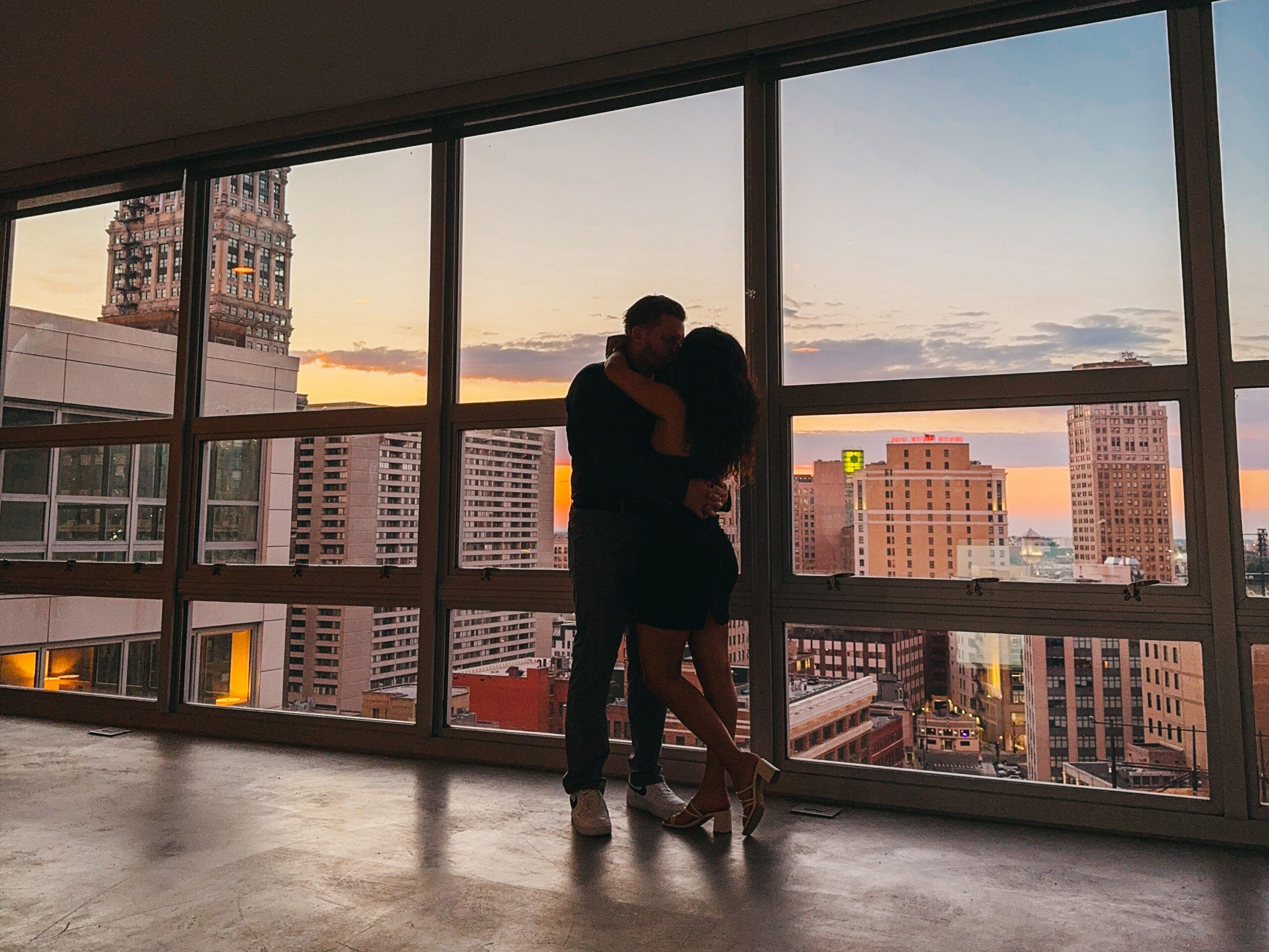 Young couple in modern apartment with city view in Spain, representing rental property appeal after renovations