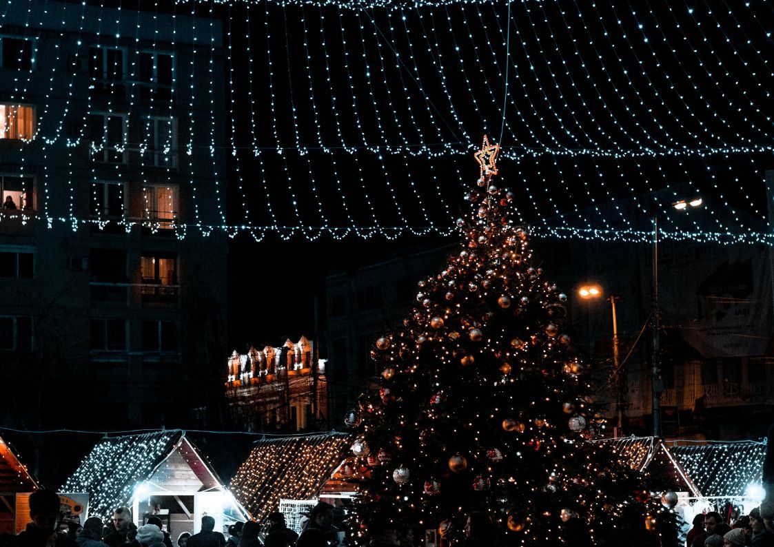 Spanish Christmas market at night with festive lights and a decorated Christmas tree.