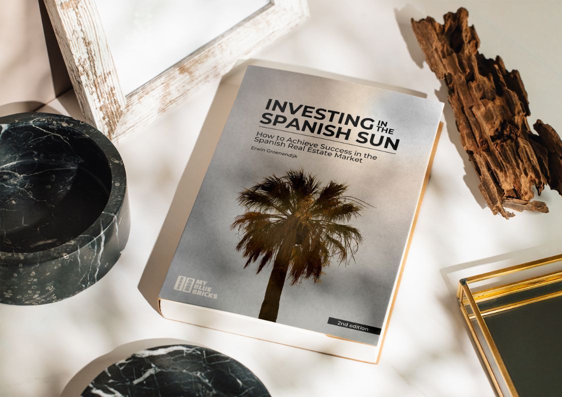 Investing in the Spanish Sun book displayed on a table with natural light and home décor items.