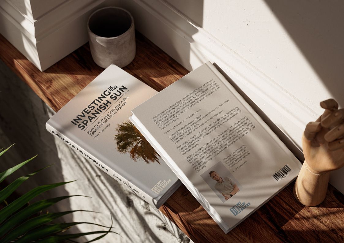 Copy of Investing in the Spanish Sun by My Blue Bricks on a wooden surface, a real estate guide to buying property in Spain