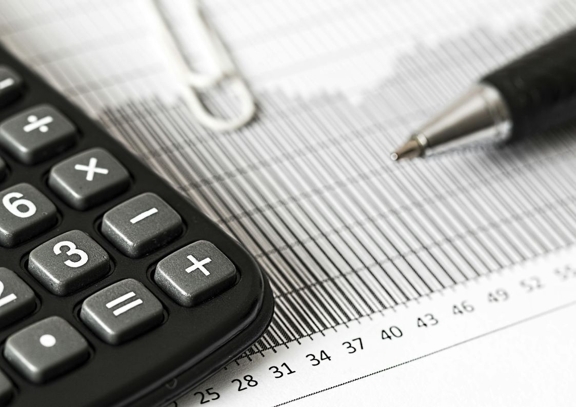 Close-up of a calculator, pen, and printed financial graph used for calculating property taxes and expenses.