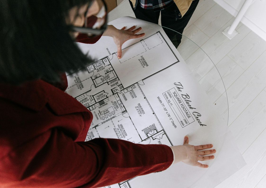 Investors analyzing an architectural floor plan layout on a table for a renovation project.