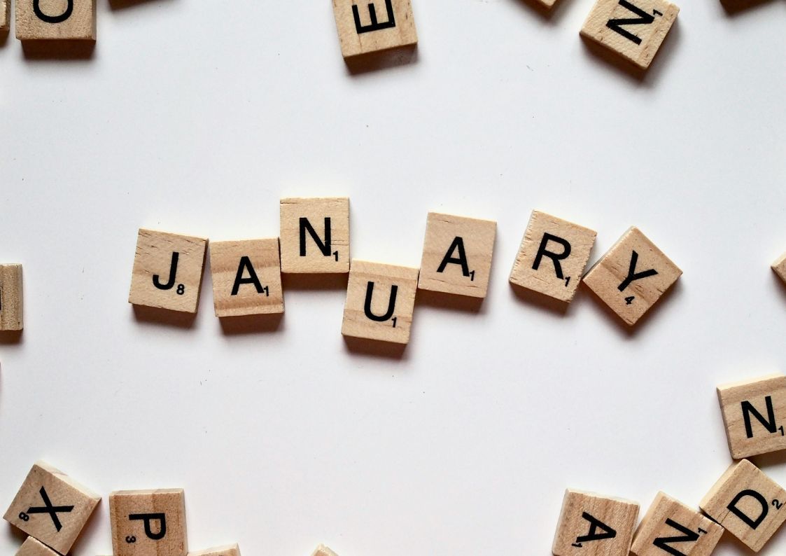 Wooden letter tiles spelling “January” on a white background symbolizing new beginnings.