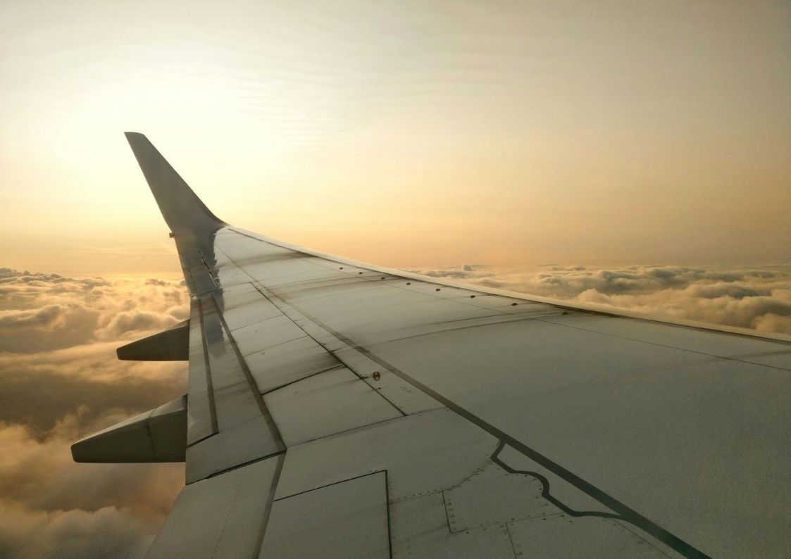 View from an airplane wing during sunset, representing relocation and moving to Spain