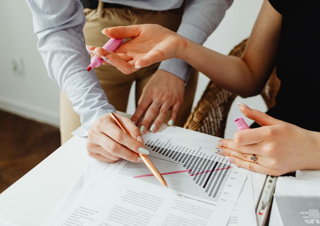 Two people reviewing charts and documents together, discussing financial strategy and investment planning.